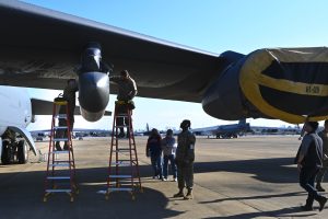 Spectators watch as an AgilePod is adjusted onto a B-52 Stratofortress, at Barksdale Air Force Base, Louisiana, Jan. 10, 2023. The AgilePod is a multi-function pod built to integrate advanced communications capabilities for the B-52 across all domains. (U.S. Air Force photo by Airman 1st Class Nia Jacobs)